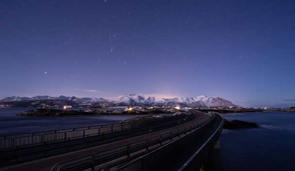Nuit avec la lune et vue sur la route de l'océan Atlantique (Atlanterhavsveien) en Norvège. Paysages et couleurs hivernaux
. - Photo, image