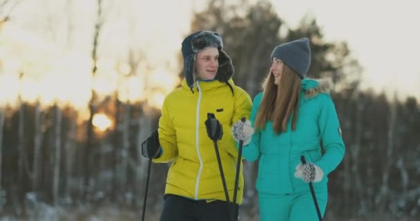 Po celé délce portrét aktivní mladý pár těší lyžování v zasněženém zimním lese, zaměřit se na usmívající se žena vpředu, kopie prostor - Záběry, video