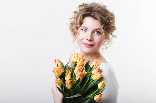 Vrouw met bloemen tulpen. Beauty en mode. - Foto, afbeelding