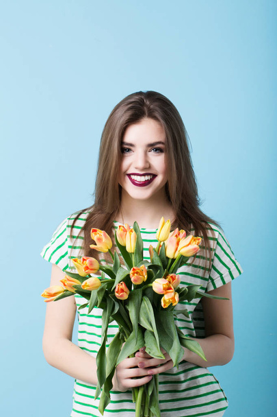 Fashion photo of a beautiful young woman with tulips. Spring concept and march 8. - Valokuva, kuva