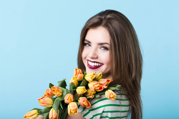 Portrait of a beautiful girl with a bouquet of tulips. Beauty and fashion. - Photo, image