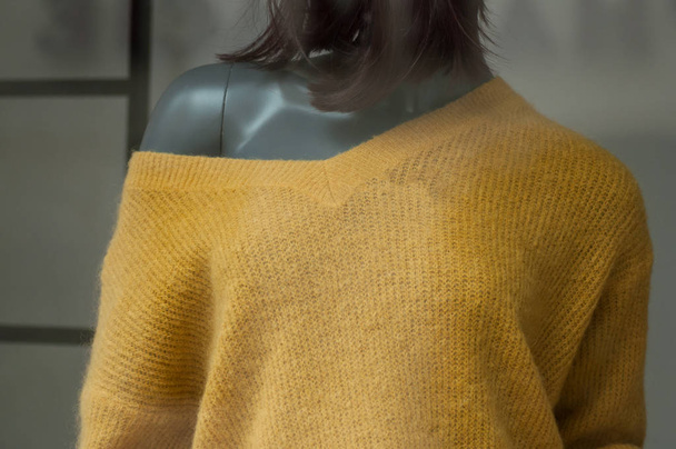 closeup of orange pullover on mannequin in fashion sotre showroom for women - Фото, зображення