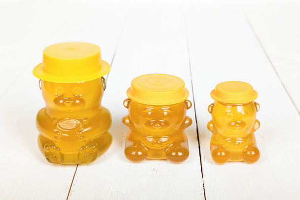 Miel à l'argousier dans des bocaux en verre sur des planches en bois blanc. Délicieux dessert doux
. - Photo, image