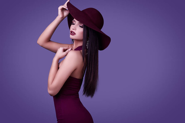 Portrét elegantní krásná bruneta ženy v barevných šatech a široký klobouk izolované na živé pozadí ve studiu - Fotografie, Obrázek
