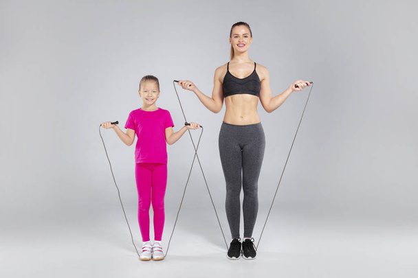 Beautiful woman and her daughter with jumping rope - Φωτογραφία, εικόνα