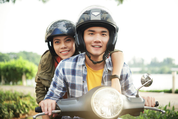 Возбужденная молодая азиатская пара путешествует по стране на скутере
 - Фото, изображение