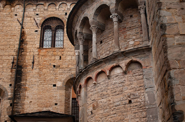 Зовнішні деталь до базиліки Святого Мері основних в Пьяцца дель Дуомо в Бергамо, Італія. Зовнішній вигляд лівого апсиди з підробленою арки з колонами і вікно. - Фото, зображення