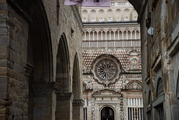 Зовнішній вигляд базиліки Святої Марії майор і Коллеоне каплиця. Стійка фасад має ряд поліхромний прикраси в кремових і рожевих тонах. Пьяцца дель Дуомо в Бергамо, Італія. - Фото, зображення