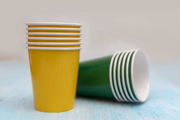 Gele en groene papier wegwerp bekers voor dranken. - Foto, afbeelding