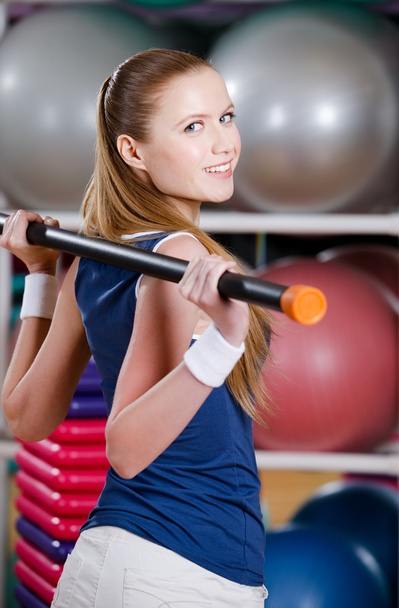 Sportive woman works out with gymnastic stick - Фото, зображення