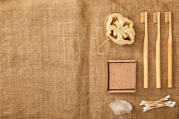 top view of different hygiene and care items on brown sackcloth surface, zero waste concept - Photo, Image