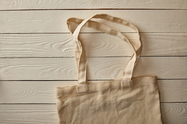 top view of empty cotton bag on white wooden surface, zero waste concept - Фото, изображение