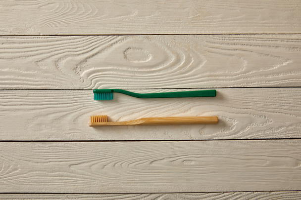 vista superior de cepillos de dientes en la superficie de madera blanca, concepto de cero residuos
 - Foto, imagen
