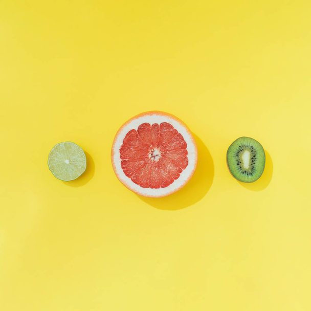 Pomelo rojo con lima y kiwi sobre fondo amarillo pastel. Concepto de verano mínimo
  - Foto, Imagen