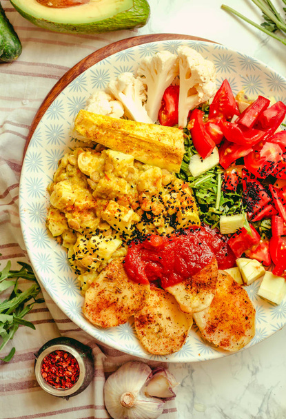 Green fresh salad with tomatoes, pink lentil mashed potatoes, baked potato slices with homemade ketchup.Full meal and Healthy vegan lunch dish concept.Top view. - Φωτογραφία, εικόνα