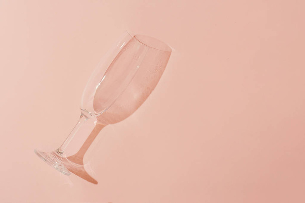 empty champagne glass on pastel coral background, Minimal style  - Zdjęcie, obraz