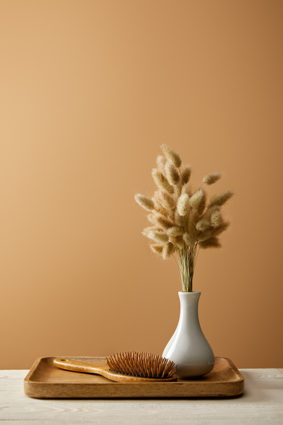 wooden tray with vase of spikelets and hair brush isolated on brown, zero waste concept - Фото, зображення