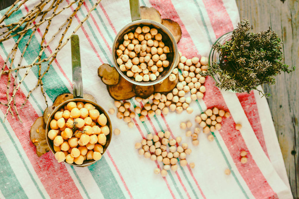 Chickpeas dry and boiled in an iron bowl, thyme. Rustik style background. Top view. Kinfolk and comfort food atmosphere concept. - Фото, зображення