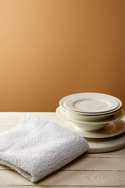 stack of plates and terry cotton towel on white wooden surface - Photo, Image