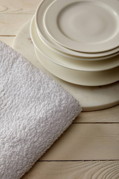 stacked plates and white terry cotton towel on white wooden surface - Photo, Image