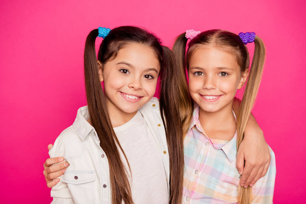 Close up photo two small little age she her girls hugging buddies like photographing gladly smiling wearing casual jeans denim checkered plaid shirts isolated rose vibrant bright vivid background - Foto, Imagen
