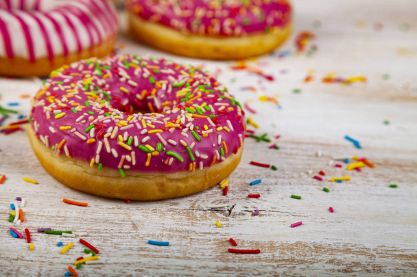 Pink donuts on a wooden background. Delicious dessert. - Photo, Image