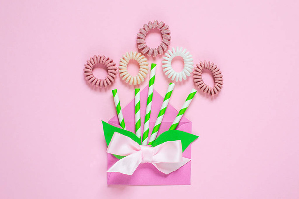Flowers from hair spiral scrunchies on pink background, creative spring concept, flat lay, woman's day - Photo, Image