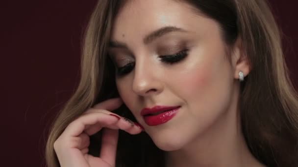 Kaunis brunette malli kiharat, klassinen meikki ja seksikäs punainen huulet
. - Materiaali, video