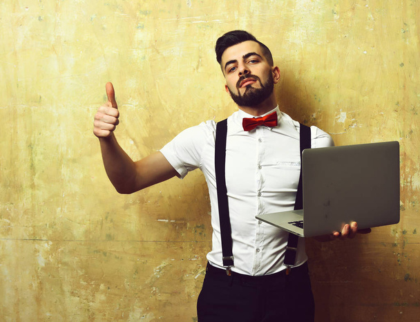 Employer with beard in white shirt and bow with laptop - Foto, afbeelding