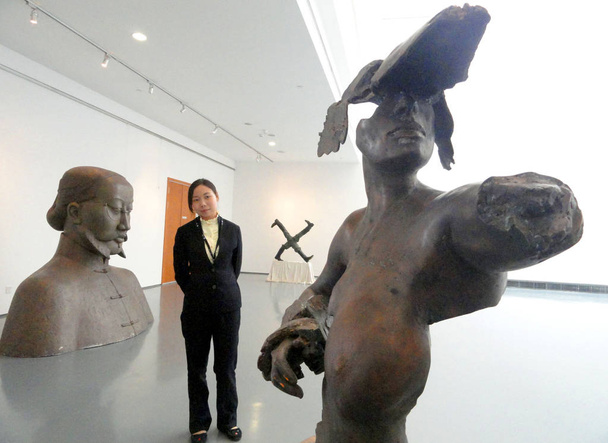 A visitor looks at a sculpture during the Exhibition on China-EU Sculptures, Dialogue with The Emperor Qins Warriors, at Suzhou Art Museum in Suzhou city, east Chinas Jiangsu province, 15 May 2012 - Photo, Image