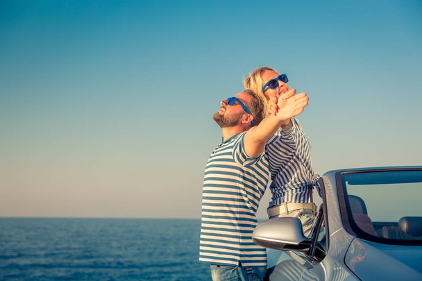 Una pareja feliz viaja en coche. Gente divirtiéndose en Blue Cabriolet. Concepto vacaciones de verano
 - Foto, imagen