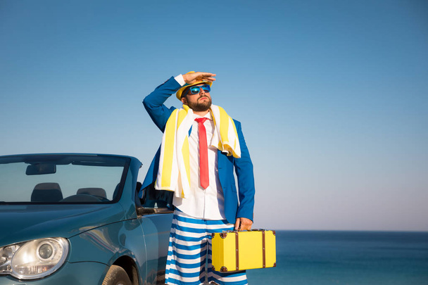 Úspěšný mladý podnikatel na pláži. Muž, který stojí v klasickém autě kabriolet. Letní prázdniny a svobodu cestování koncepce - Fotografie, Obrázek