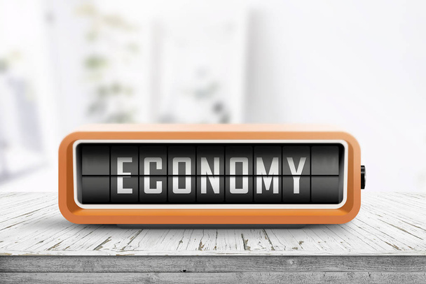 Slovo ekonomiky na analogové zařízení ve světlé domácnosti na dřevěné desce - Fotografie, Obrázek