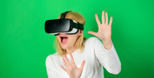 Young woman using a virtual reality headset with conceptual network lines. Funny woman experiencing 3D gadget technology - close up. Amazed young woman touching the air during the VR experience. - Фото, изображение