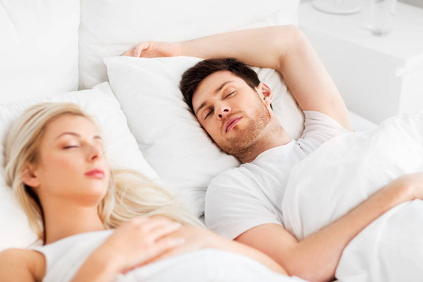 happy couple sleeping in bed at home - Foto, Imagen