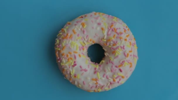 Heerlijke zoete donut draaien op een blauw bord. Bovenaanzicht. - Video