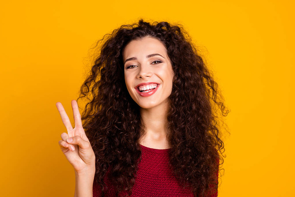 Close up photo beautiful amazing her she lady arm friendly show two fingers like hippie love people v-sign wearing maroon knitted sweater clothes outfit isolated yellow bright background - 写真・画像