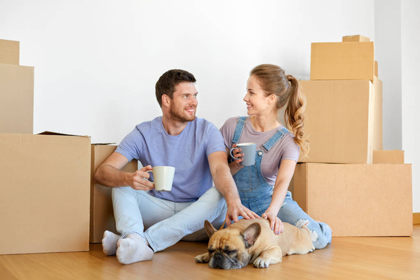 ボックスと新しい家に移動の犬と幸せなカップル - 写真・画像