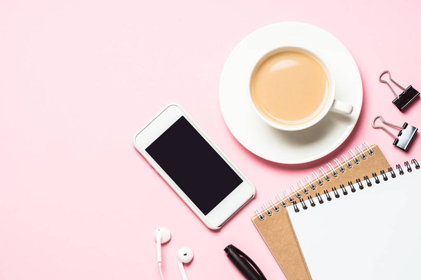 weiblicher Home-Office-Arbeitsplatz mit Notizblock, Kaffeetasse, Sukkulente und Maus auf rosa - Foto, Bild