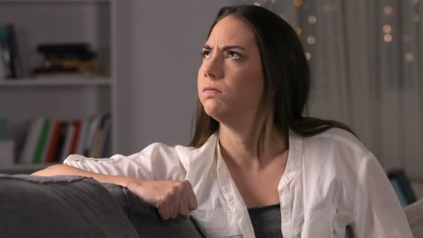 Mujer enojada cubriendo oídos sufriendo ruido vecino sentado en un sofá en casa en la noche
  - Metraje, vídeo