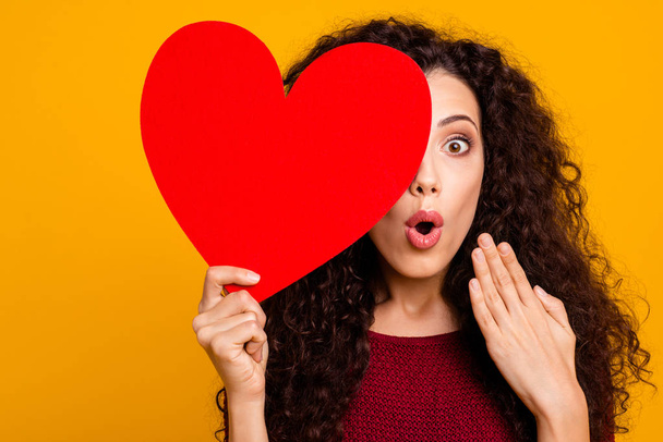 Close-up portrait of nice cute lovely attractive cheerful cheery funny wavy-haired lady holding in hand hiding behind big heart shape isolated over bright vivid shine background - Fotoğraf, Görsel