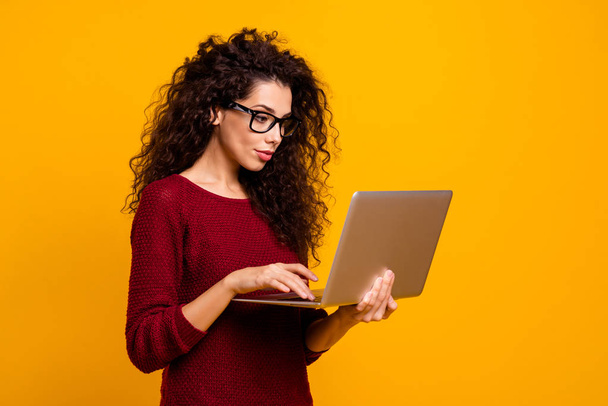 Profile side view portrait of her she nice clever smart intelligent genius cute attractive pretty cheerful wavy-haired lady holding in hands laptop isolated over bright vivid shine orange background - Zdjęcie, obraz