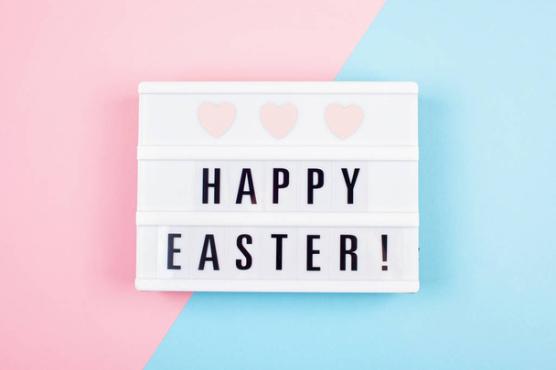 Light box over the pastel background with the text Happy Easter. Easter celebration concept - Fotoğraf, Görsel