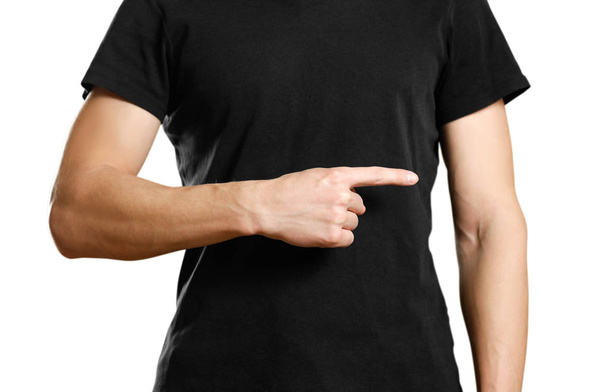 A man in a t-shirt pointing to the side. Close up. Isolated background. - Φωτογραφία, εικόνα