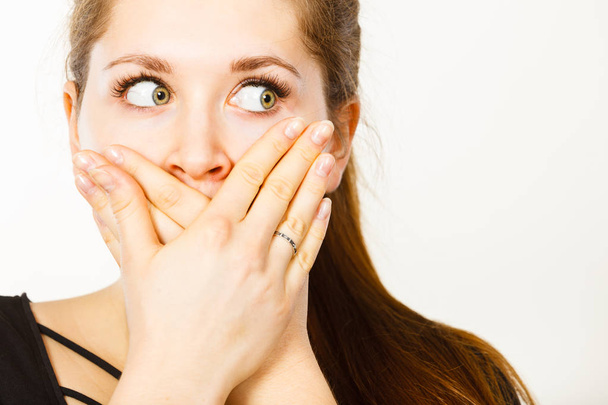 Woman covering her mouth with hand. Seeing something shocking, surprised and speechless face expression. - Foto, imagen