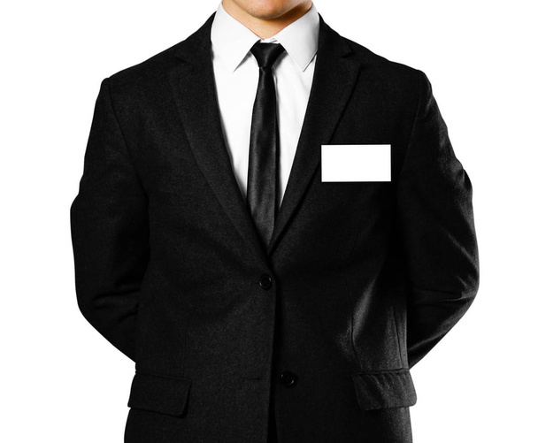 Επιχειρηματία σε ένα μαύρο κοστούμι, λευκό πουκάμισο και γραβάτα. Στούντιο γυρίσματα. Με το σήμα. Απομονωμένα σε λευκό φόντο. - Φωτογραφία, εικόνα