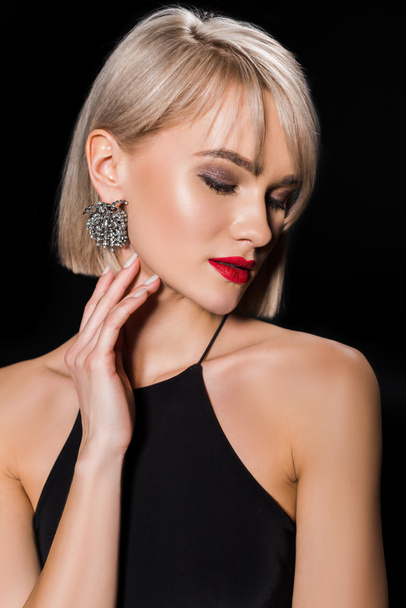 beautiful glamour woman in earrings and black dress, isolated on black - Foto, immagini