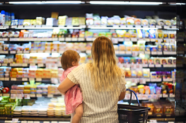 Веселая мать и ребенок проводит время в магазинах в супермаркете, мелкая глубина резкости
  - Фото, изображение