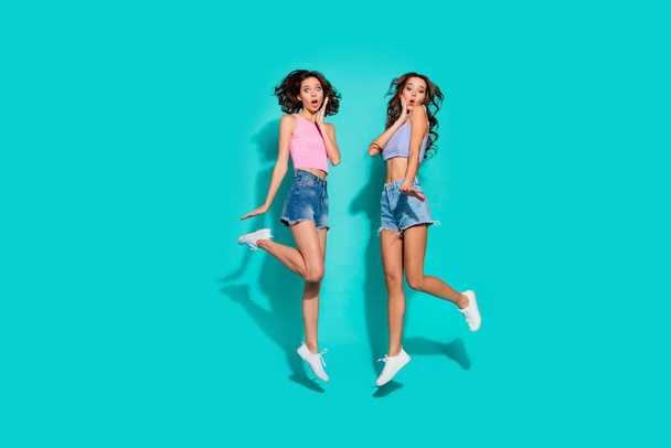 Full length body size side profile photo jumping beautiful funky wavy she her ladies hands arms cheeks unexpected news wearing pink blue jeans denim shorts tank tops isolated teal vivid background - Φωτογραφία, εικόνα