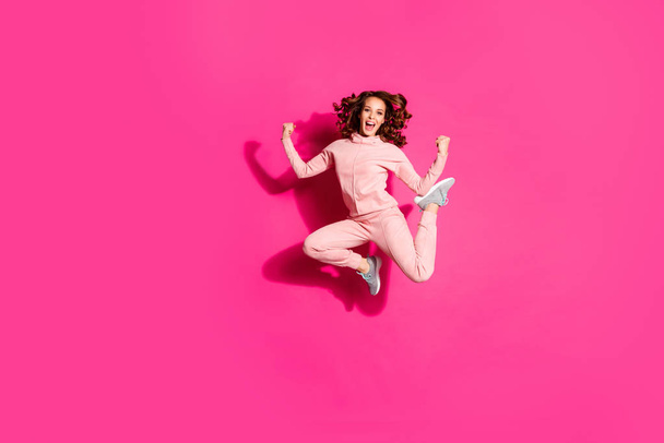 Full length body size photo jump high amazing she her party lady hands arms fists raised great flexibility wearing casual pink costume suit pullover outfit isolated bright vibrant rose background - Foto, imagen